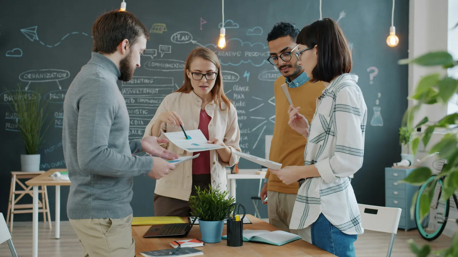 Equipo de una empresa revisando gráficos y documentación en una reunión de trabajo