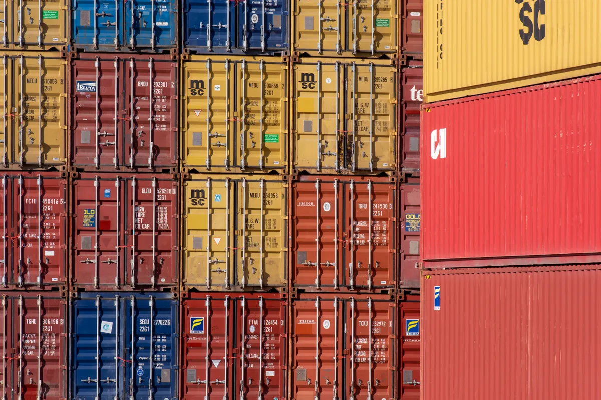 Contenedores de mercancías apilados en una terminal, fotografía de stock