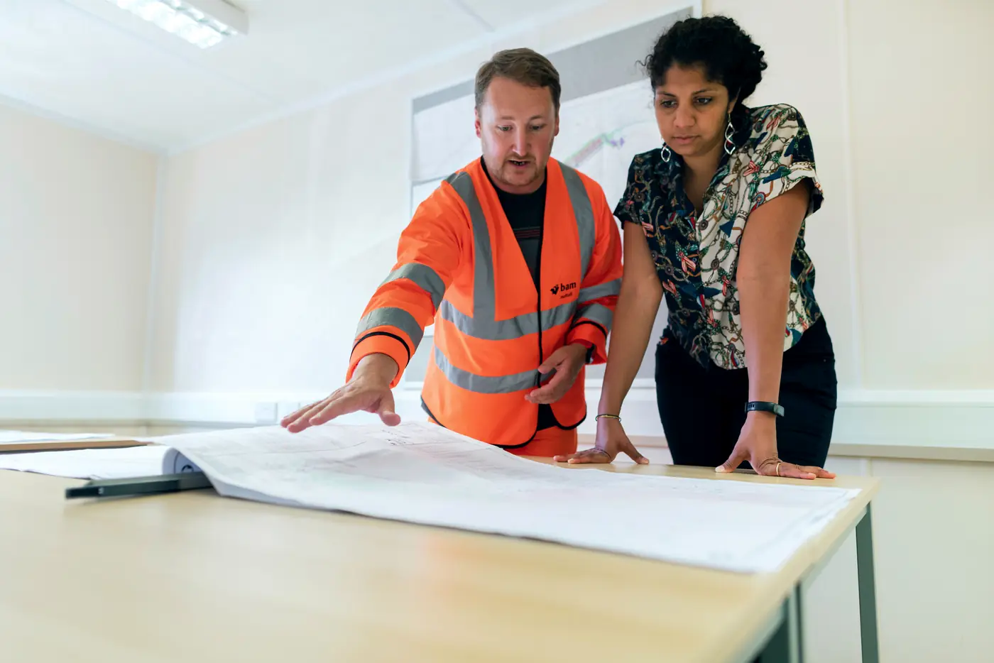 Equipo de ingeniería revisando planos y decisiones de un proyecto en una mesa de trabajo